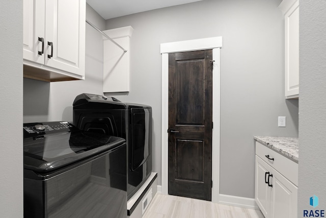 clothes washing area featuring cabinet space, independent washer and dryer, and baseboards