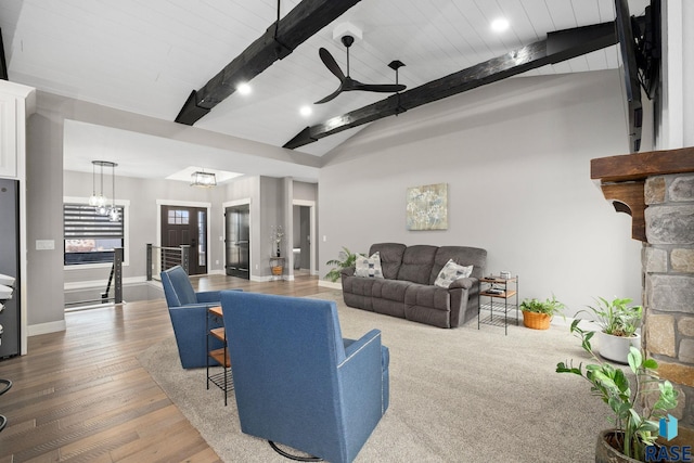 living area with a ceiling fan, lofted ceiling with beams, baseboards, and wood finished floors