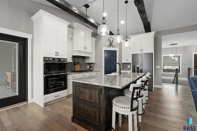 kitchen with gas stovetop, decorative backsplash, dark wood-style flooring, and stainless steel fridge with ice dispenser