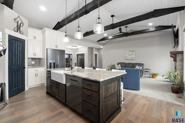 kitchen with open floor plan, white cabinetry, a sink, stainless steel fridge, and dishwashing machine