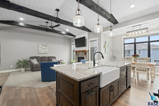 kitchen featuring a fireplace, a sink, and light wood-style flooring