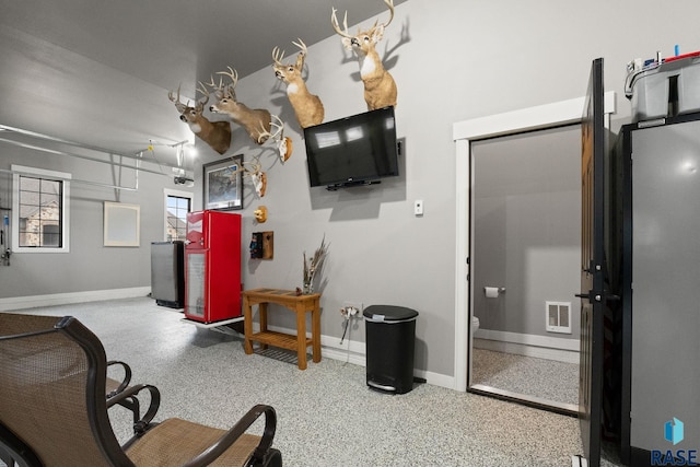 interior space featuring baseboards, visible vents, and speckled floor