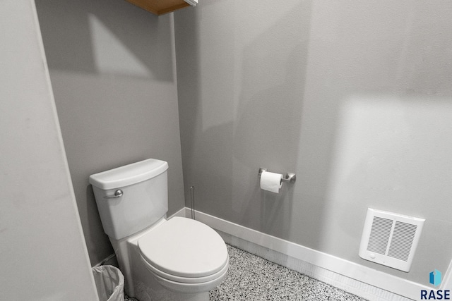 bathroom featuring toilet, visible vents, and baseboards