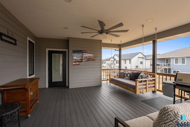 wooden deck with a residential view, outdoor lounge area, and ceiling fan