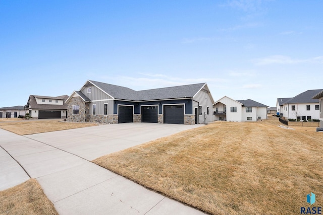 view of front of home featuring an attached garage, stone siding, concrete driveway, a residential view, and board and batten siding