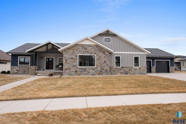 craftsman-style home featuring concrete driveway, board and batten siding, a garage, stone siding, and a front lawn