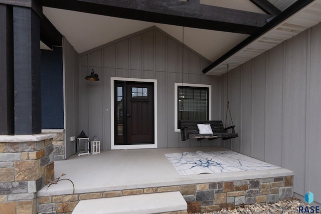 property entrance with stone siding and board and batten siding