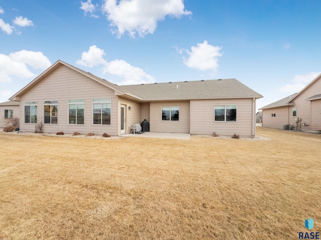 rear view of house featuring a yard and a patio