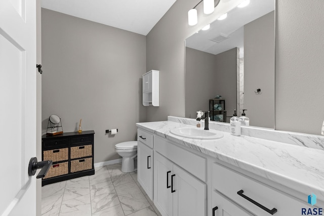 bathroom with marble finish floor, toilet, vanity, and baseboards