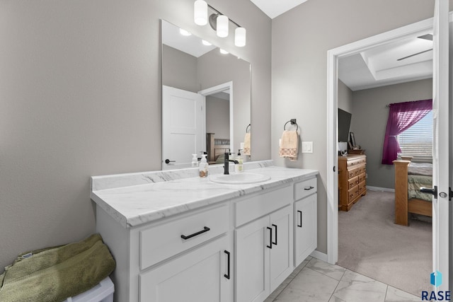 bathroom with marble finish floor, vanity, and baseboards