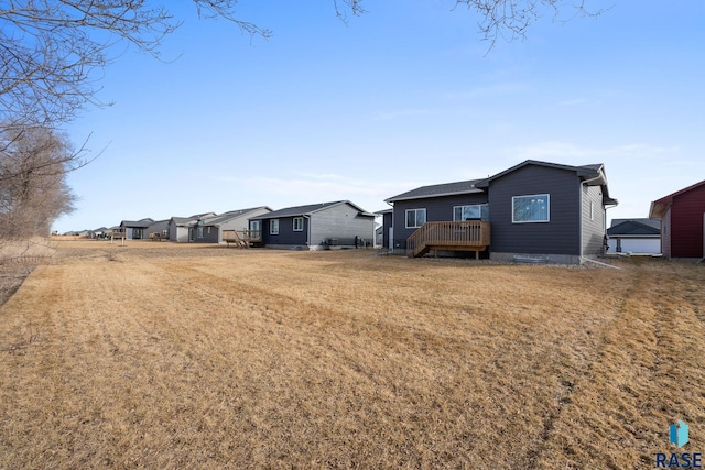 exterior space with a residential view, a deck, and a front lawn