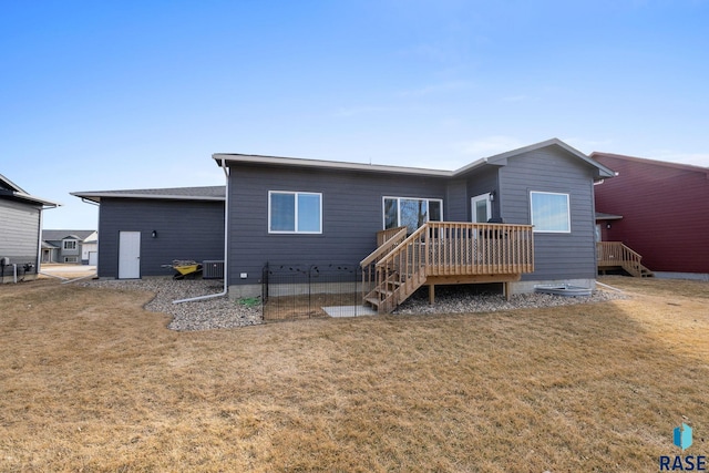 rear view of house with a deck, a lawn, and central air condition unit