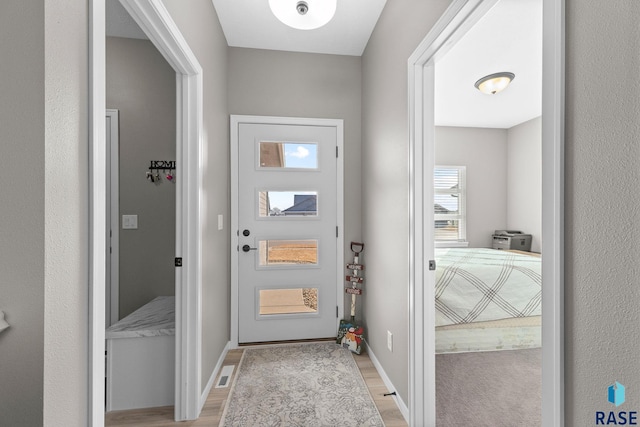 entryway featuring light wood finished floors and baseboards