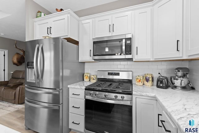 kitchen featuring white cabinetry, appliances with stainless steel finishes, and decorative backsplash