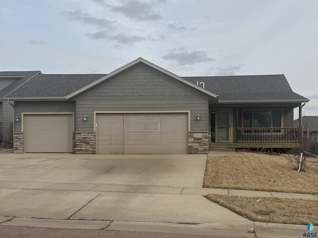 ranch-style house with an attached garage, stone siding, a shingled roof, and concrete driveway