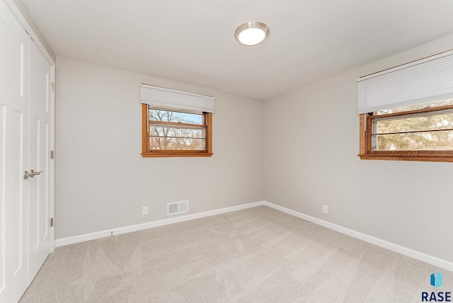 unfurnished bedroom with carpet flooring, visible vents, and baseboards