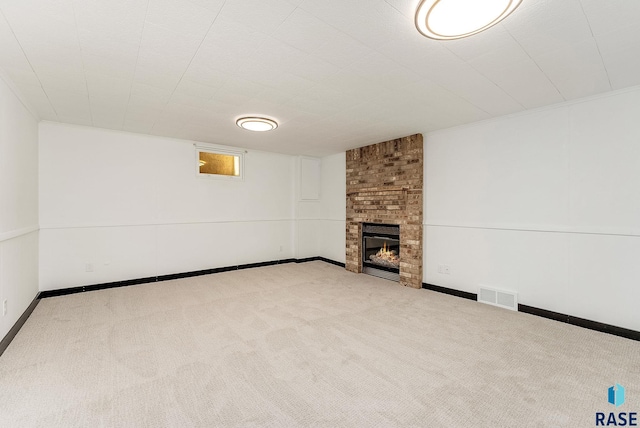 below grade area with carpet, a fireplace, visible vents, and baseboards