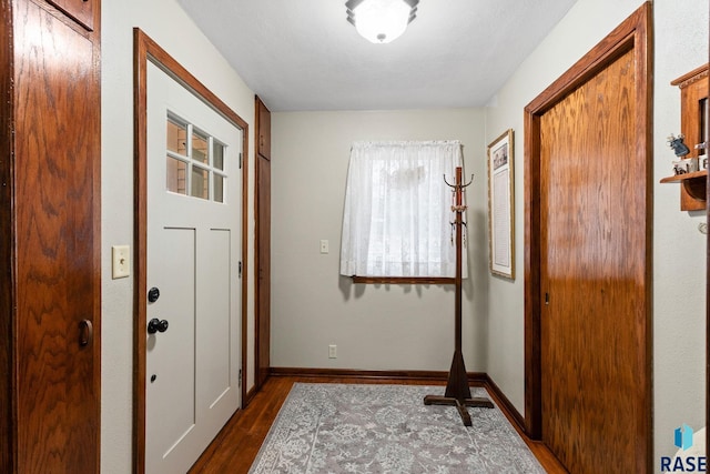 entryway featuring dark wood-type flooring and baseboards