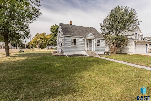 view of front of home with roof with shingles, a chimney, a front yard, entry steps, and a garage