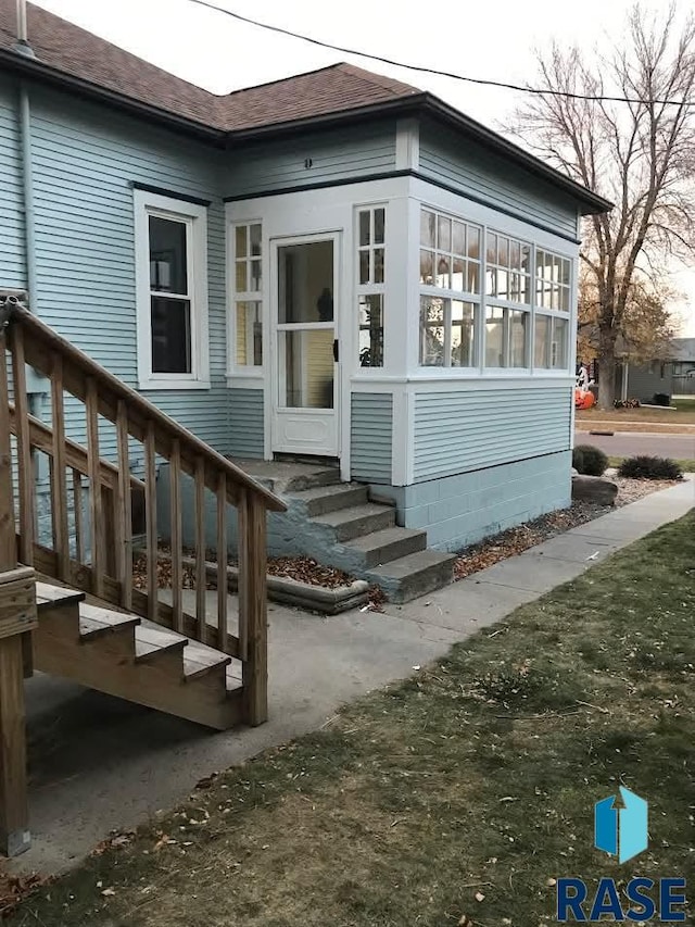 property entrance with roof with shingles