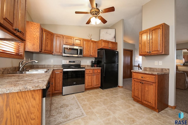 kitchen featuring appliances with stainless steel finishes, lofted ceiling, brown cabinetry, and a sink