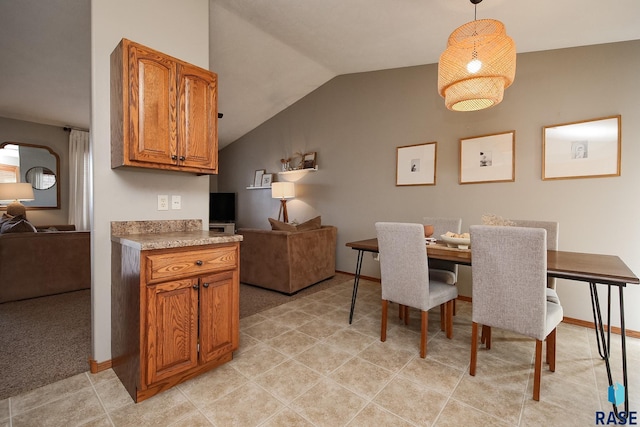 dining room with lofted ceiling, light tile patterned flooring, and baseboards