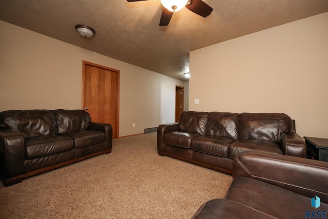 carpeted living area with ceiling fan, a textured ceiling, and baseboards