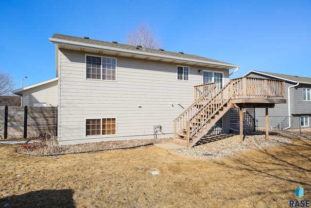 back of property featuring a yard, fence, a deck, and stairs