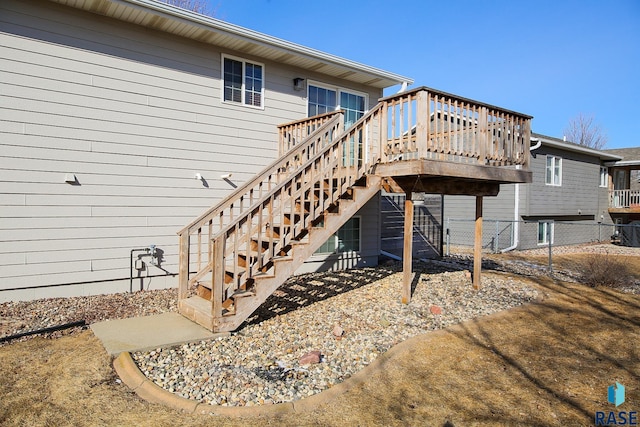 back of property featuring fence, stairway, and a wooden deck