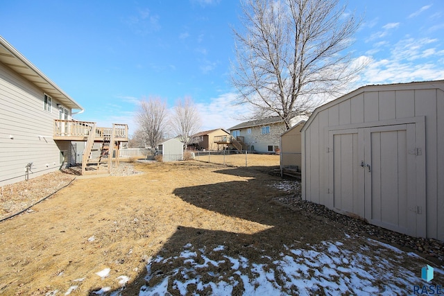 view of yard featuring an outbuilding, fence, a deck, a shed, and stairs