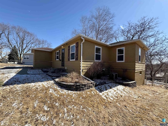 view of side of home with central AC and stucco siding