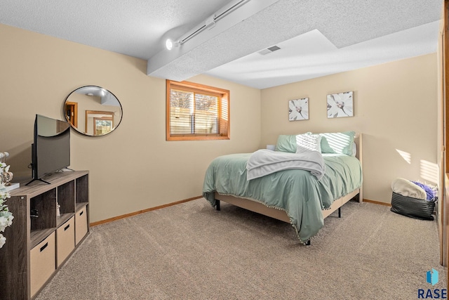 bedroom with light carpet, a textured ceiling, visible vents, and baseboards