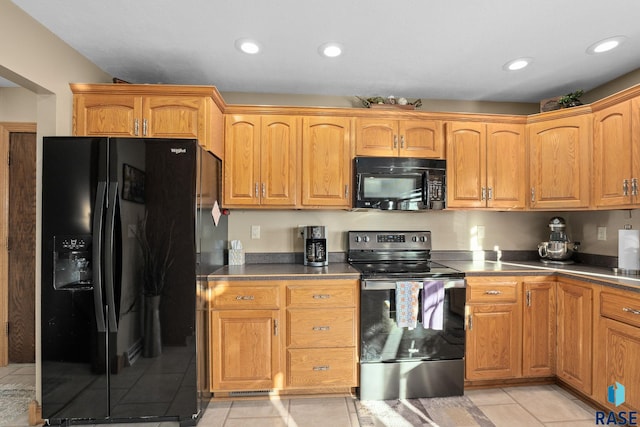 kitchen with recessed lighting, light tile patterned flooring, dark countertops, and black appliances