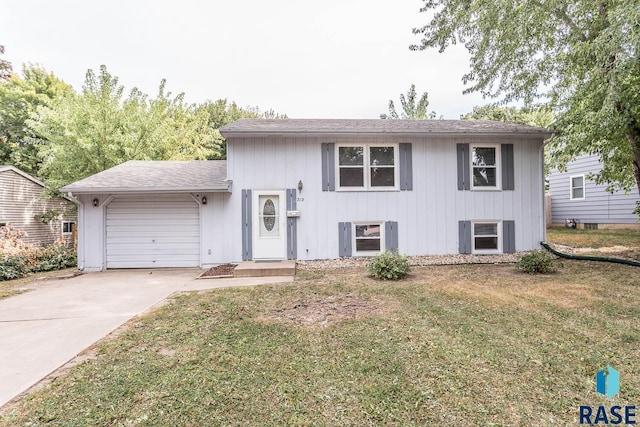 tri-level home with a garage, concrete driveway, and a front yard