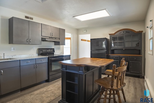 kitchen featuring visible vents, under cabinet range hood, black appliances, open shelves, and a sink