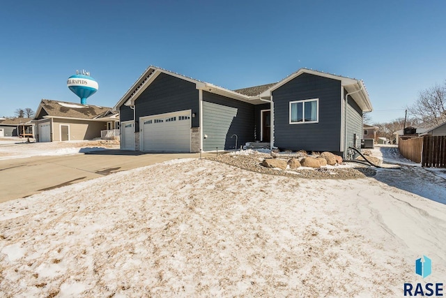 single story home featuring an attached garage, driveway, and fence