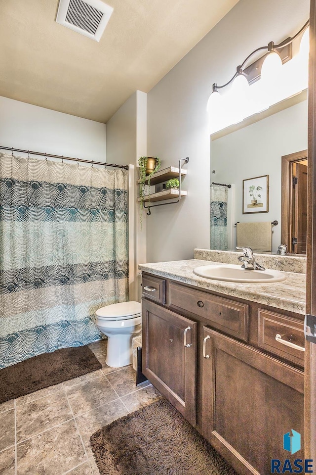 bathroom featuring toilet, visible vents, and vanity