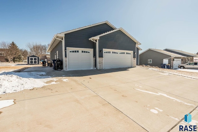 view of front of property featuring an outbuilding, concrete driveway, a storage shed, and a garage