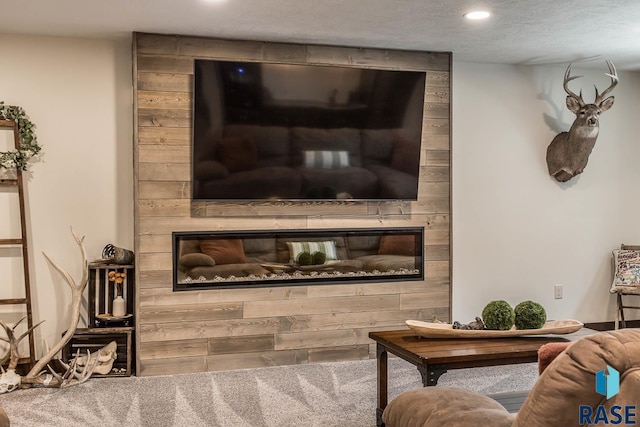 living room featuring recessed lighting, a fireplace, a textured ceiling, and carpet