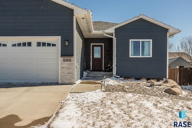 view of front of home featuring an attached garage and fence