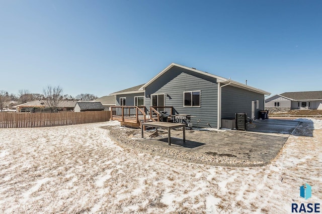 rear view of house with a deck, a patio area, and fence