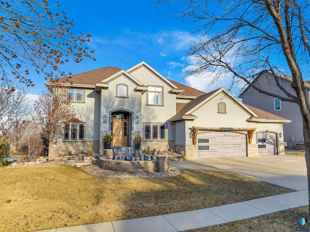 view of front of home featuring an attached garage, concrete driveway, stone siding, stucco siding, and a front lawn