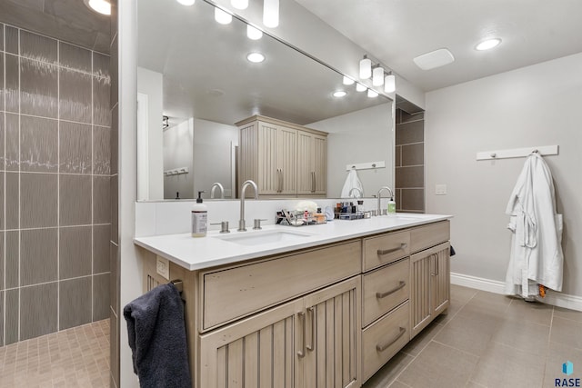 full bath with double vanity, baseboards, tile patterned flooring, walk in shower, and a sink