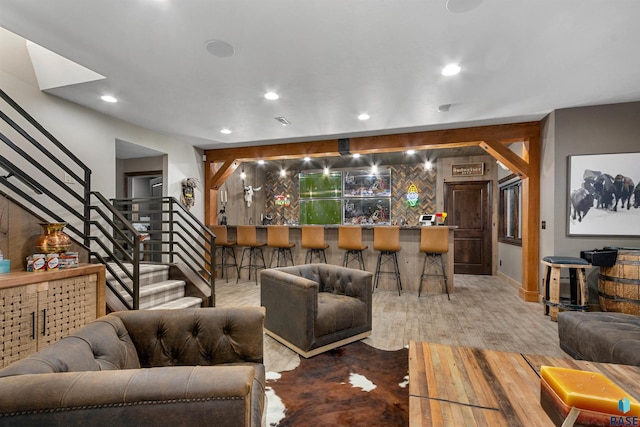 living area featuring stairs, wood finished floors, indoor wet bar, and recessed lighting