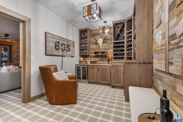 wine area with beverage cooler, light carpet, and baseboards