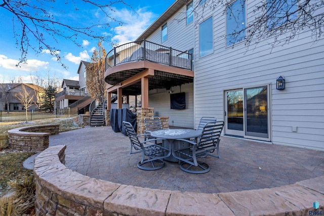 view of patio / terrace with outdoor dining area, fence, a wooden deck, and stairs