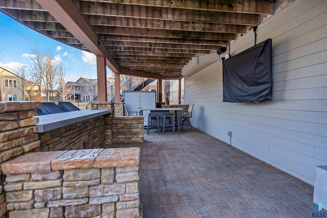 view of patio with fence and outdoor dry bar