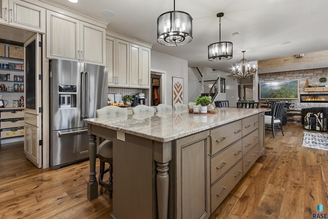 kitchen featuring decorative light fixtures, high end refrigerator, hardwood / wood-style flooring, and a notable chandelier