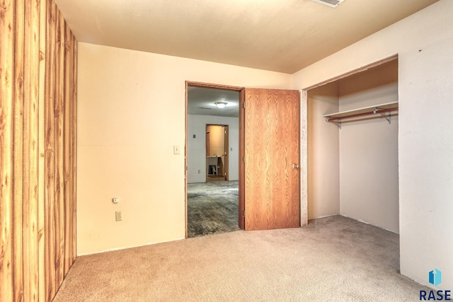 unfurnished bedroom with a closet and carpet flooring