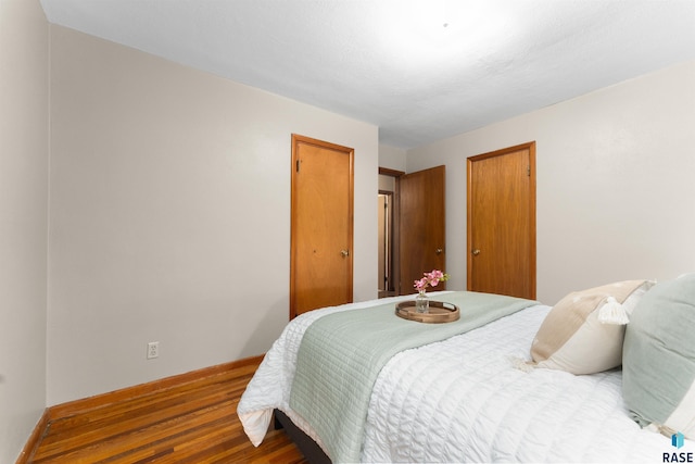 bedroom featuring baseboards and wood finished floors